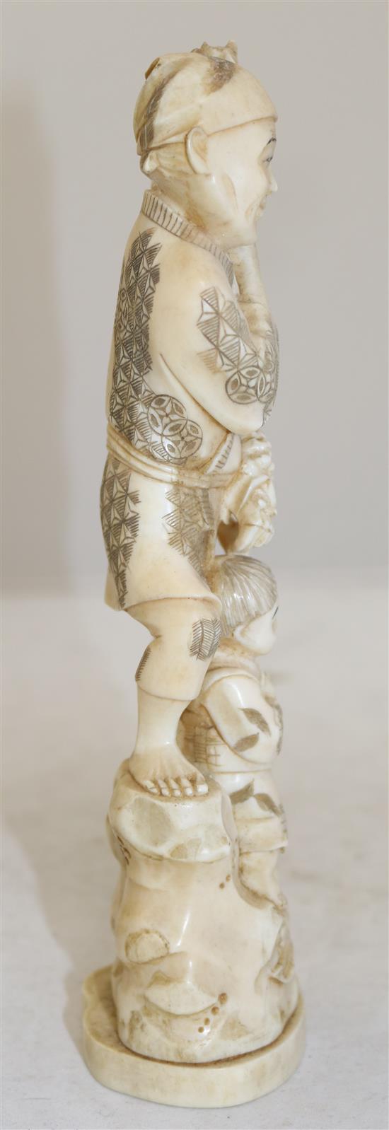 A Japanese walrus ivory okimono of a man and a boy, early 20th century, 23.5cm